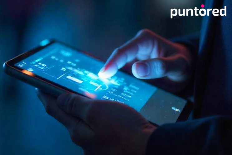 Manos interactuando con una tablet que muestra el logo de Puntored, simbolizando seguridad en pagos digitales